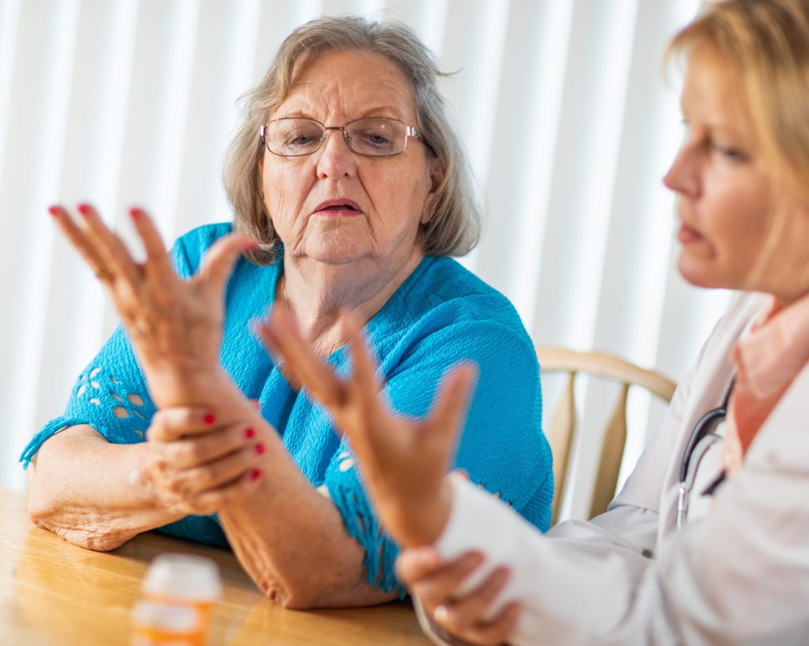 Female Doctor Talking with Senior Adult Woman About Hand Therapy.